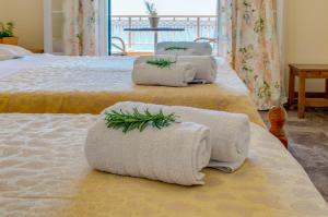 Tres camas con toallas encima. en Naftis Apartments en Pelekas