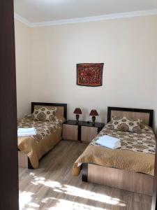 1 dormitorio con 2 camas y una foto en la pared en Saroy Guest house, en Samarkand