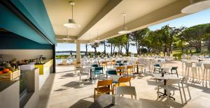 a restaurant with tables and chairs on a patio at Padova Premium Camping Resort by Valamar in Rab