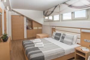 1 dormitorio con 1 cama grande y toallas. en Hotel Epavlis Eleftheriadi, en Paralia Katerinis