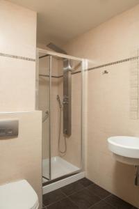 y baño con ducha, aseo y lavamanos. en Hotel Epavlis Eleftheriadi, en Paralia Katerinis