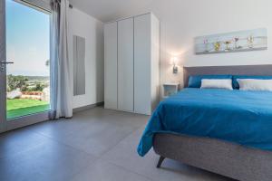 a bedroom with a blue bed and a large window at B&B Naracheddu Elite in Santa Teresa Gallura +68 photos