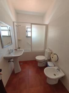 a bathroom with two toilets and a sink at A Toca Do Grilo in Carvalhal