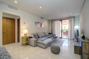 sala de estar con sofá azul y TV en Dream Garden Flat- Sotoserena, en Estepona