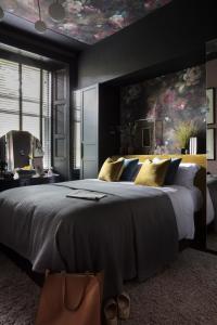a bedroom with a large bed with a painting on the wall at Luxury Boutique Apt in fashionable Stockbridge 5* in Edinburgh