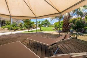 a picnic table and chairs under a large umbrella on a deck at B&B Le Dune - Self Check in in Lascari