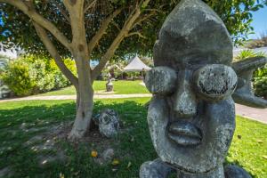 a statue of a face in a park at B&B Le Dune - Self Check in in Lascari