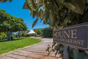 a sign that reads dune bed and breakfast on a wooden path at B&B Le Dune - Self Check in in Lascari