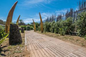 a wooden walkway in a garden with a fence at B&B Le Dune - Self Check in in Lascari