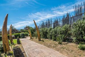 a wooden walkway with a fence in a garden at B&B Le Dune - Self Check in in Lascari