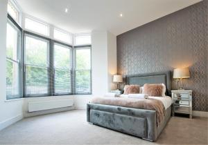 1 dormitorio con 1 cama grande en una habitación con ventanas en Rowan Tree - Your Apartment en Bristol