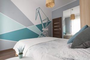 ein Schlafzimmer mit einem Bett und einer blauen Wand in der Unterkunft NAP Apartments Mila Baltica gym&sauna in Danzig