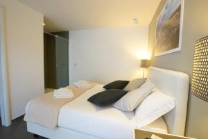 a white bed in a room with a mirror at Le Stanze di Piazza Cairoli in Messina