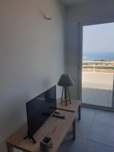 een woonkamer met een flatscreen-tv en een tafel bij Corsica Résidence Galitello in Monticello