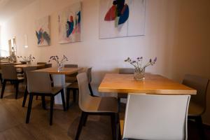 a restaurant with wooden tables and chairs and flowers on the wall at Vrachia Beach Hotel & Suites - Adults Only in Paphos