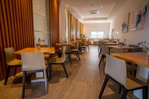 a dining room with tables and chairs in a restaurant at Vrachia Beach Hotel & Suites - Adults Only in Paphos