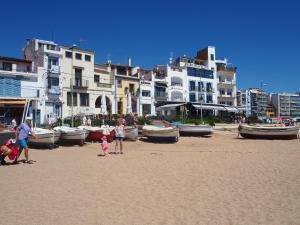un groupe de personnes debout sur une plage avec des bateaux dans l'établissement APARTAMENTO MAR I CEL, à Blanes