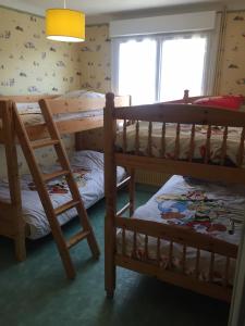 a bedroom with two bunk beds and a window at Les Palmiers in Pornic