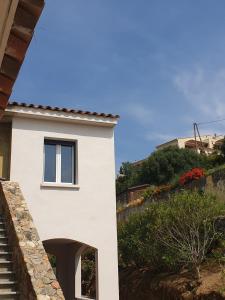 - un bâtiment blanc avec une fenêtre sur le côté dans l'établissement Corsica Résidence Galitello, à Monticello