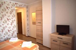 a bedroom with a bed and a television on a dresser at Family Hotel "Slavianska dusha" - FREE PARKING in Veliko Tŭrnovo