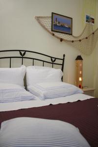 a bed with white pillows and a picture on the wall at La Cascata in Noci