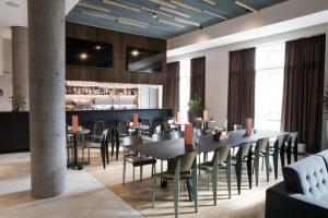 a dining room with a table and chairs and a bar at Fosshotel Reykjavík in Reykjavík