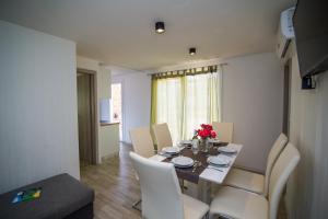 a dining room with a table with white chairs and flowers on it at Mobile Homes Pine Tree in Dobropoljana