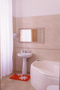 a bathroom with a sink and a tub and a toilet and a mirror at Pałac Brody in Brody
