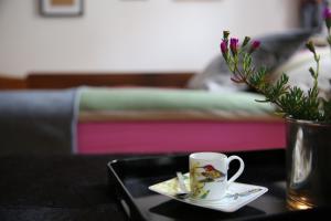 a table with a coffee cup and a plate with flowers at Kolovrathome in Ljubljana