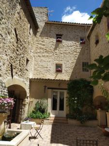 a stone building with a door and a patio at Le Térébinthe B&B in Lauris