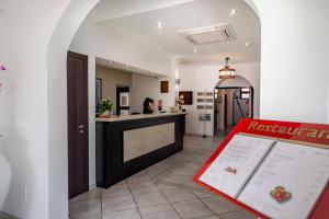 a room with a kitchen and a counter with a table at Hotel Baia Del Capitano in Cefalù