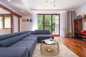 a living room with a blue couch and a table at Beachfront Apartment Haga with Free Parking by Renters in Sopot