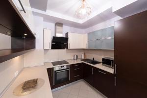 a kitchen with black and white appliances and a ceiling at Beachfront Apartment Haga with Free Parking by Renters in Sopot