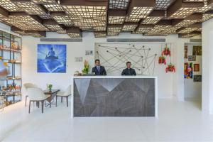 two men standing at a counter in a room at Dragonfly Hotel- The Art Hotel in Mumbai