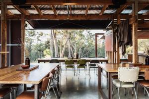 a dining room with wooden tables and chairs at Bay of Fires Bush Retreat in Binalong Bay