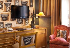 een kamer met een bureau, een televisie en een stoel bij Hôtel Horset Opéra, Best Western Premier Collection in Parijs
