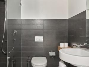 a bathroom with a sink and a toilet and a shower at Hotel Tödi in Linthal +22 photos