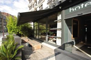 a store front with a bench in front of a building at Hotel Niza in Donostia-San Sebastián
