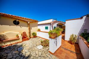 a courtyard of a house with potted plants at Hotel Baia Del Capitano in Cefalù