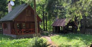 a small cabin and a pavilion in the woods at Forest Cottage Weekend House in Vlăhiţa