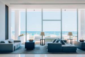a living room with two couches and large windows at Iberostar Selection Lagos Algarve in Lagos