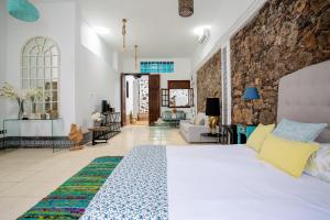 a bedroom with a bed and a living room at El Charco Suites in Arrecife
