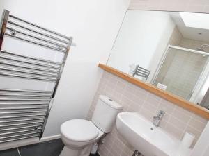 a bathroom with a toilet and a sink and a mirror at The Old Dairy in Padstow +15 photos