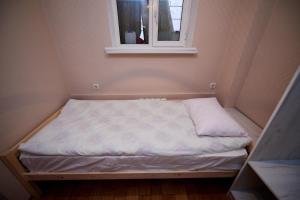 a small bed in a small room with a window at Wanderlust Hostel in Almaty