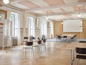 a conference room with tables and chairs and a whiteboard at Hotel Tödi in Linthal