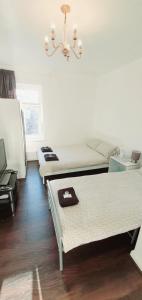グリムズビーにあるRegent Guest Houseのベッド2台とシャンデリアが備わる客室です。