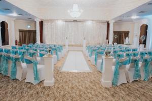 阿斯克Cwrt Bleddyn Hotel & Spa的宴会厅配有蓝色和白色的椅子和桌子 更多37张照片
