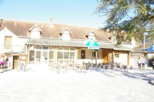 a building with tables and chairs in front of it at BVCO LOCATIONS PROCHE CHATEAUX ET BEAUVAL DANS LE LOIR et CHER in Onzain