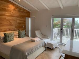 ein Schlafzimmer mit einem Bett und einem Balkon in der Unterkunft The Beach House - Glentana in Glentana