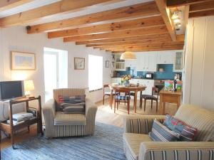 a living room with a couch and chairs and a kitchen at Pegs in Porthleven